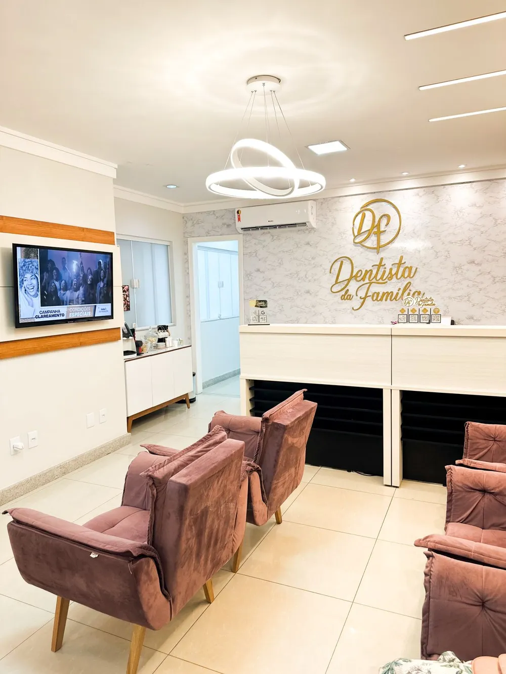Recepção da Clínica Dentista da Família, em Aracruz, com o logotipo da clínica na parede.